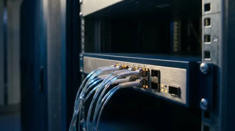 Fiber optic kabels aangesloten op een high-performance netwerkswitch in een professioneel serverrek in een datacentercorridor.